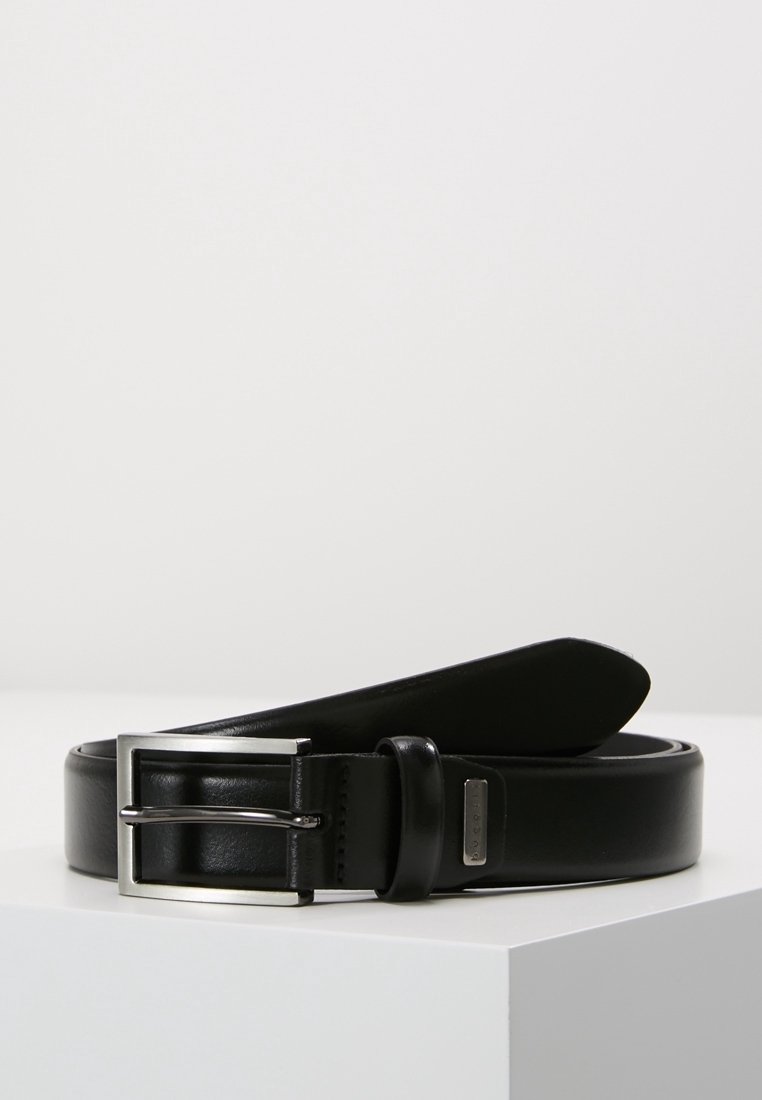 Ceinture en cuir noir avec boucle rectangulaire argentée et petite étiquette de marque métallique, enroulée sur une surface blanche sur fond clair.