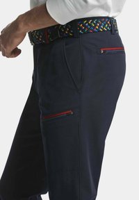 Helle cargo-Hosen in Marineblau mit einer glatten Textur, ausgestattet mit Reißverschlusstaschen mit roten Akzenten und einem buntengewebten Gürtel. Die Seitenansicht zeigt Passform und Design.