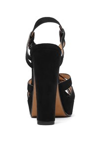 Sandali con tacco alto in suede nero, caratterizzati da un tacco grosso, apertura sul retro e sottili cinturini alla caviglia regolabili. Suola testurizzata con interno beige.