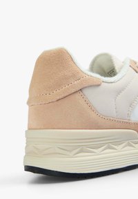 Hellrosa Wildleder- und weiße synthetische Sneaker mit strukturiertem Fersenbereich, gepolstertem Schaft und cremefarbener Laufsohle mit geometrischem Muster.