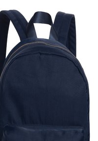 Sac à dos bleu marine en tissu à texture lisse, présentant une forme arrondie, une fermeture éclair et des bretelles ajustables.