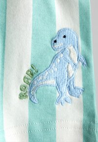 Niebieski, haftowany dinozaur z białymi detalami oraz zielonym napisem "ROAR!" na tkaninie w turkusowo-białe paski.