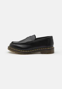 Sorte skinnloafers med mokkasinsøm, gummisåle og gule sømdetaljer. Rund tå og lav profil.