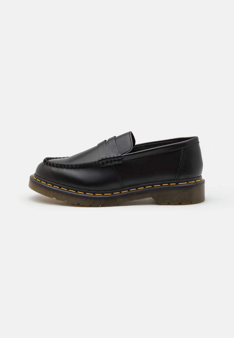 Sorte skinnloafers med mokkasinsøm, gummisåle og gule sømdetaljer. Rund tå og lav profil.