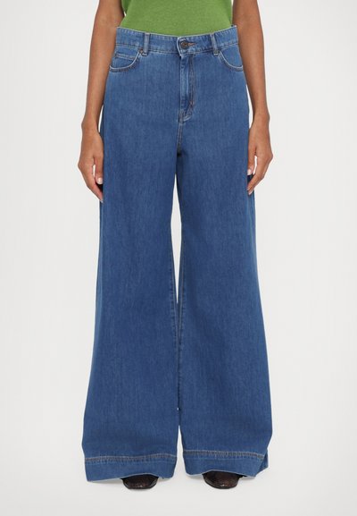 Weite Denim-Jeans in mittlerem Blau, mit Knopfverschluss, vorderen Taschen und einem sauberen Saum. Hergestellt aus weichem, robustem Denim-Stoff.