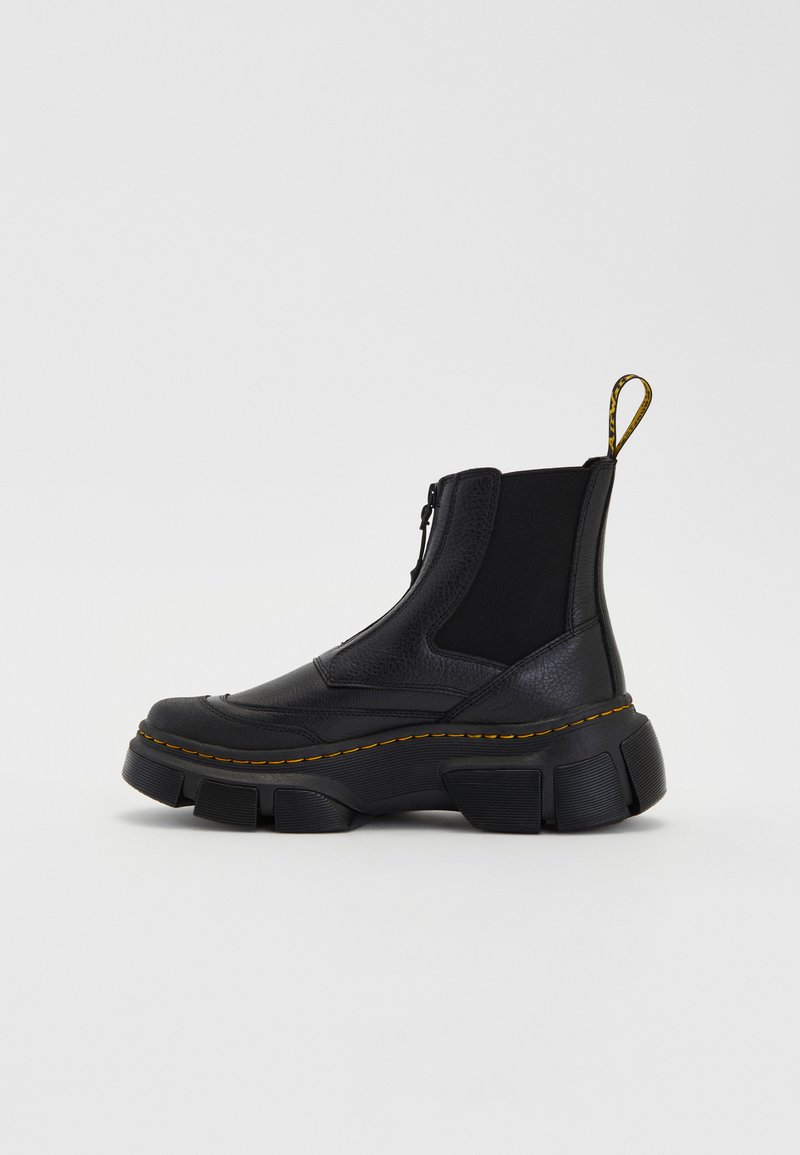 Stivaletti neri realizzati in pelle testurizzata e tessuto elastico. Suola in gomma spessa con cuciture gialle e una linguetta posteriore per una facile calzata.