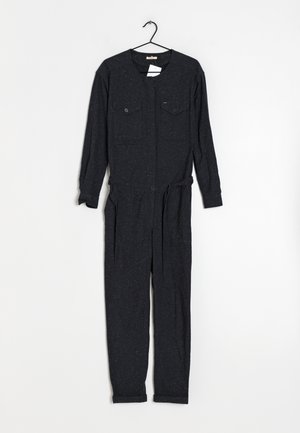 Černý overal s dlouhými rukávy, dvěma předními kapsami, stahovacími šňůrkami v pase a ohrnutými manžetami. Materiál má tečkovanou strukturu.