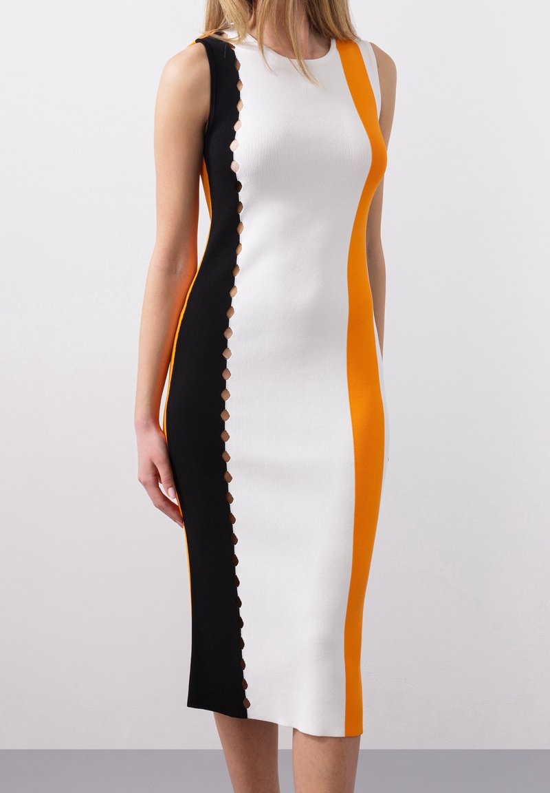 Robe midi sans manches avec panneaux verticaux noirs, blancs et orange et détails de découpes circulaires le long de la couture noir et blanc.