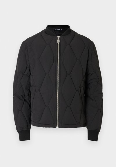 Μαύρο μπουφάν bomber με ραμμένη επένδυση, στρογγυλή λαιμόκοψη, ασημένιο φερμουάρ και ελαστικά μανίκια. Χαρακτηρίζεται από διακοσμητικά μοτίβα σε σχήμα ρόμβου στην επιφάνεια.