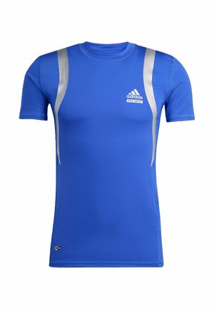 Blaues Sportshirt aus glattem Stoff. Verfügt über silberne Akzente an den Schultern und ein kleines Logo auf der Brust. Kurze Ärmel.