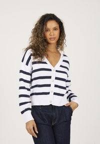 Sweter w paski w kolorze białym i granatowym, z dekoltem w serek, długimi rękawami, zapięciem na guziki oraz prążkowaną strukturą na mankietach i dolnej krawędzi.