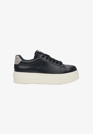 Black leather sneaker with a textured grey heel accent, platform sole, round toe, and six eyelets for laces. Smooth surface with minimal perforations.