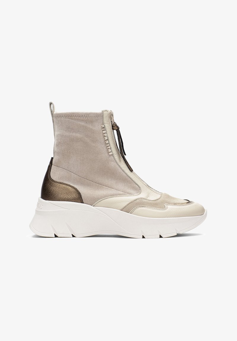 Botín grueso en gamuza y cuero beige con un acento metálico bronce, cremallera negra y suela de goma blanca con acabado texturizado.