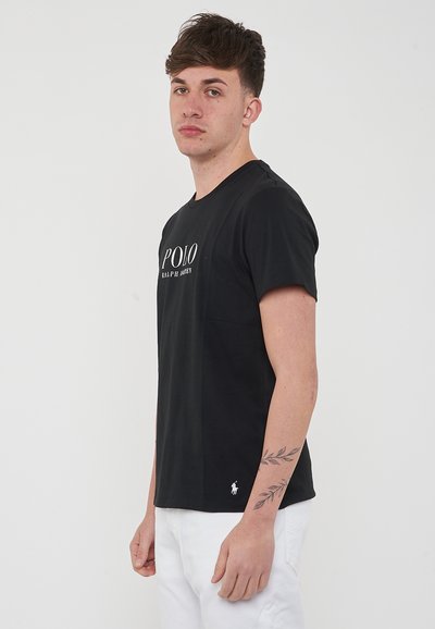 T-shirt in cotone nero con maniche corte, caratterizzato da un logo bianco "POLO RALPH LAUREN" sul davanti e un piccolo logo ricamato sull'orlo.