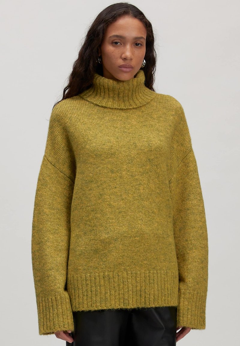 Geelgroen oversized sweater met een hoge geribde kraag, lange mouwen en een getextureerde brei, voorzien van geribde manchetten en onderrand.