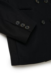 Blazer negro de doble botonadura hecho de tejido texturizado, con un bolsillo en el pecho y botones detallados con un acabado brillante.