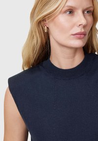 Navy mouwloze gebreide top met een hoge ronde halslijn, met subtiele naaddetails en een gladde textuur.