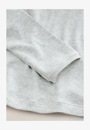 Maglietta grigia chiara a maniche lunghe con una texture a coste, caratterizzata da un collo rotondo e bordi cuciti. Tessuto morbido e elastico.