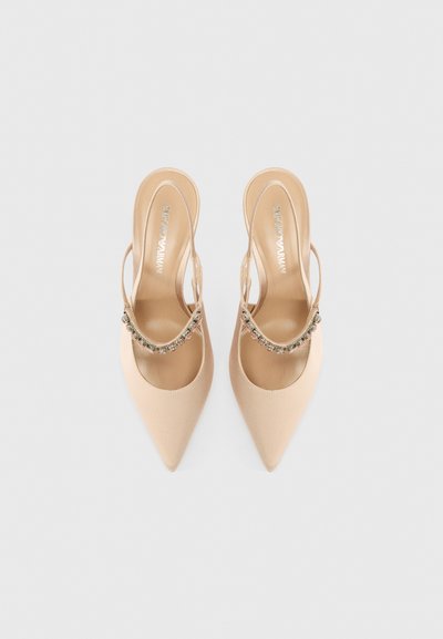 Beżowe szpilki satynowe z odkrytą piętą, zakończone w szpic z ozdobnym paskiem wysadzanym kryształkami na podbiciu. Gładka faktura, otwarty tył.