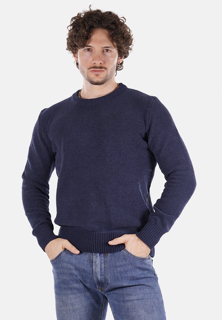 Maglione lavorato a maglia blu navy con collo rotondo, polsini e orlo a coste. Indossato sopra jeans azzurri, il tessuto testurizzato aggiunge profondità. Vestibilità casual.