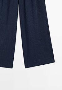 Pantalon large bleu marine foncé avec coutures latérales visibles, présenté de la mi-cuisse à la cheville sur fond blanc.