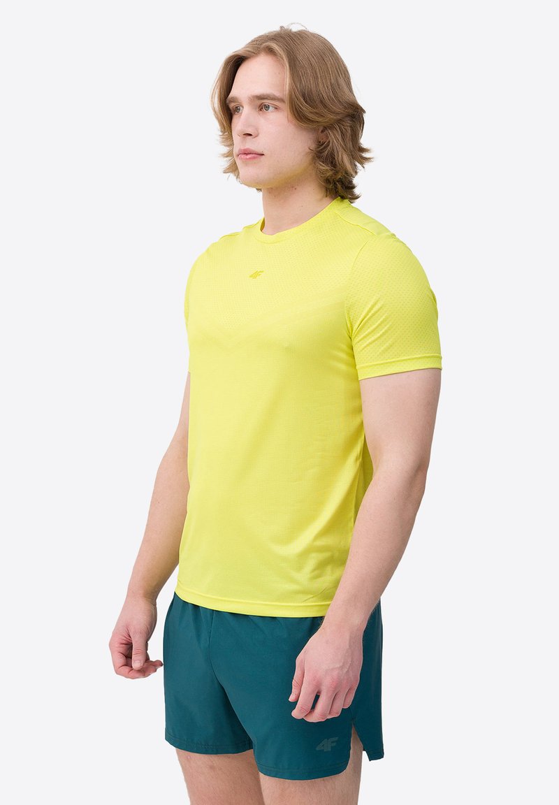 Tricou sportiv cu mâneci scurte, de culoare galben vivid, fabricat dintr-un material respirabil cu un model texturat; asortat cu pantaloni scurți teal.