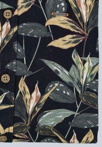 Kurzärmliges Hemd mit dunklem Hintergrund und einem floralen Muster aus grünen und goldenen Blättern, versehen mit braunen Knöpfen zum Schließen.