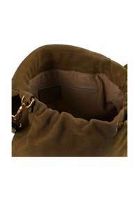 Slordige bruine suède tas met een ingenomen opening en een binnenvak met ritssluiting. Gouden metalen accenten. Zachte textuur en afgeronde vorm.