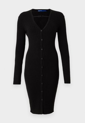 Robe en maille côtelée noire avec un décolleté en V, des manches longues et une rangée de boutons à l'avant. Silhouette ajustée se rétrécissant à la taille, longueur genou.