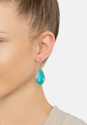 Teardrop earrings featuring a turquoise stone with a crackled pattern, framed in gold-tone metal. Hook closure for secure wear.