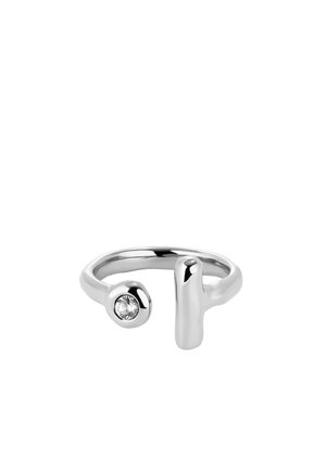 Bague en argent présentant un design lisse et courbé, avec une pierre transparente ronde d'un côté et un accent saillant de l'autre.