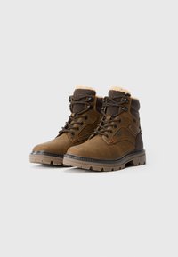 Bruine leren veterschoenen voor de winter met gewatteerde kragen en bontvoering, robuuste rubberen zolen, weergegeven tegen een eenvoudige lichte achtergrond.