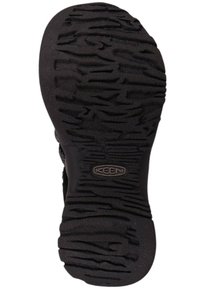 Semelle extérieure en caoutchouc noir présentant des motifs texturés et des rainures pour l'adhérence, avec un logo KEEN embossé près de la zone du talon.