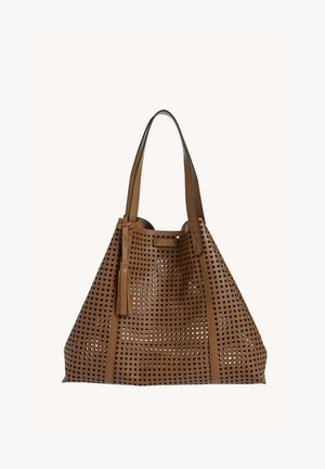 Sac fourre-tout en cuir marron avec des perforations en forme de cœur, des doubles bretelles et un gland décoratif suspendu à une bretelle.