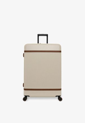 Beige harde koffer met verticale ribbels, bruine horizontale accenten, intrekbare zwarte handgreep en vier zwarte draaibare wielen.