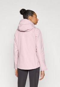 Ανοιχτό ροζ αδιάβροχο μπουφάν με κουκούλα, με λεία υφή και εφαρμοστή σχεδίαση. Περιλαμβάνει ρυθμιζόμενες μανσέτες και ίσιο τελείωμα.