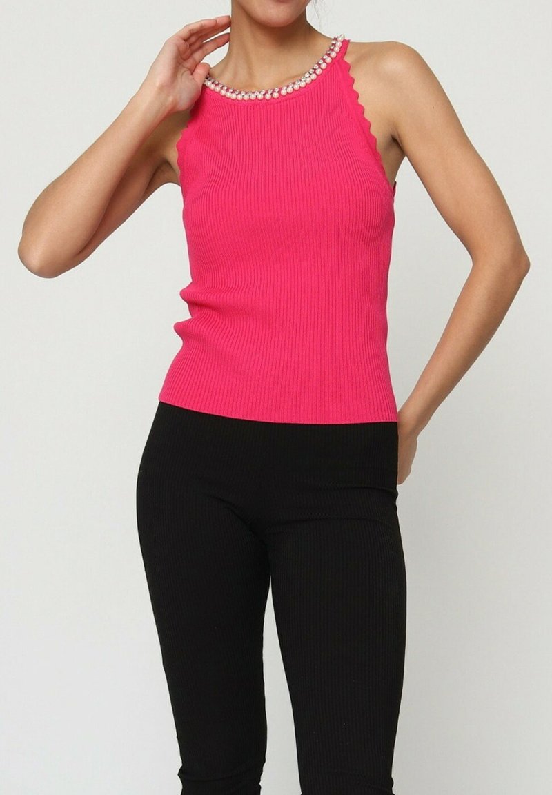 Débardeur côtelé fuchsia avec un col en dentelle et des détails ornés, associé à des leggings côtelés noirs, silhouette ajustée.