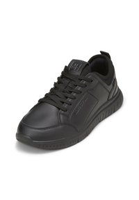 Scarpe sportive nere con tomaia in pelle sintetica, chiusura con lacci, collarino imbottito e suola in gomma con texture e leggero tacco.