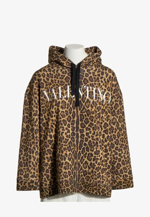 Mikina s leopardím vzorem, černými šňůrkami a bílým nápisem „VALENTINO“ přes prsa, vystavená na bílém torso figuríny.