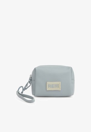 Piccola pochette da polso grigio chiaro con una toppa in tessuto sulla parte anteriore e una tracolla staccabile agganciata al lato.