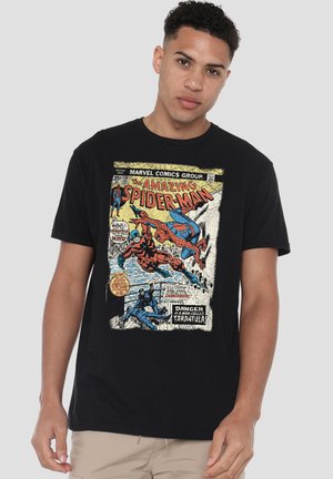Young man wearing black t-shirt with vintage Amazing Spider-Man comic cover featuring Spider-Man and Tarantula characters.