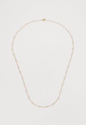 Kuldne kaelakee ringikujuliste kristallaktsentidega, mis on ühtlaselt jaotatud, õrn tekstuur ja lukuga sulgemine, loodud mitmekesisuseks.