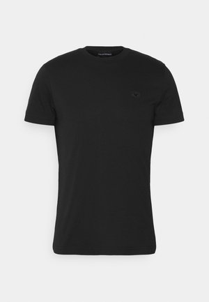 Camiseta negra de manga corta hecha de algodón, con un cuello redondo y un pequeño logo oscuro en el pecho, con una textura suave.