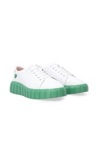 Weiße Schnürsneaker mit einer strukturierten grünen Gummisohle, die ein kleines grünes Herzakzent an der Außenseite und ein Obermaterial aus glattem Leder aufweisen.
