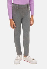 Leggings grises hechos de un material suave y elástico con una textura lisa. Tienen bolsillos falsos y una cómoda cinturilla elástica.