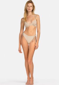 Beżowy zestaw bikini z marszczonym topem w kształcie trójkąta i wysokim stanem z wiązaniem z boku. Gładka tekstura z minimalną ilością szwów.