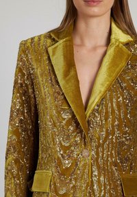 Velvet blazer in olijfgroen met een sequined golfpatroon, gepunte kraag, enkele knoopsluiting en twee voorzakken.