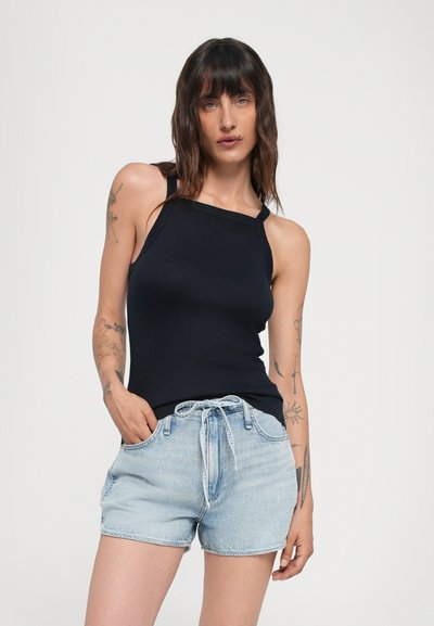 Débardeur noir à côtes avec de fines bretelles, associé à un short en denim bleu clair avec taille à cordon de serrage et poches avant.
