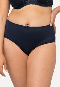 Culotte taille haute bleu marine en tissu doux, avec un détail de nœud délicat à la taille et des bords lisses et élastiques.