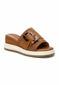 Infradito in tessuto intrecciato marrone con una suola bianca chunky, caratterizzate da una grande fibbia in stile tartaruga e una plantare liscia color tan.